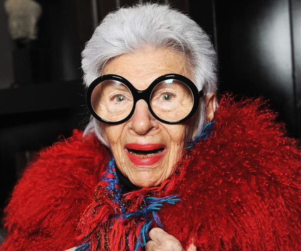 Iris Apfel in red coat and coloured scarf